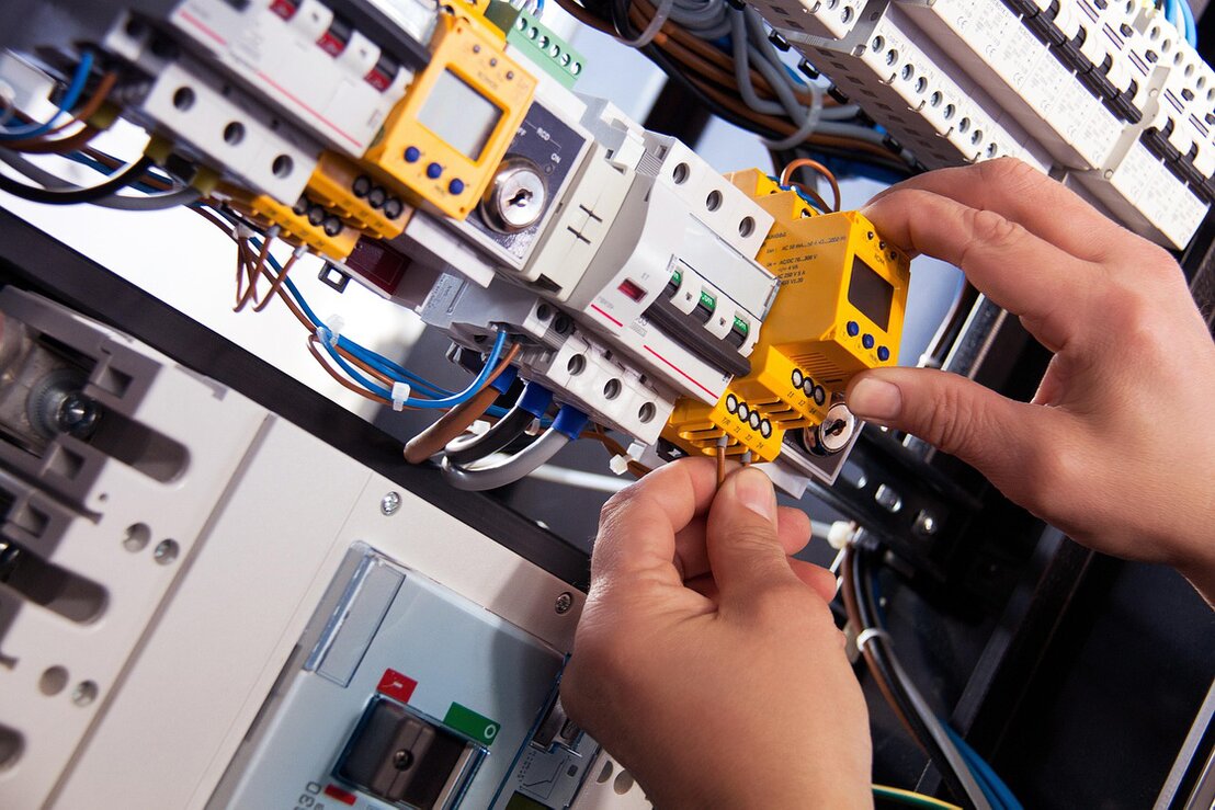 Elettricista al lavoro su un quadro elettrico in cantiere